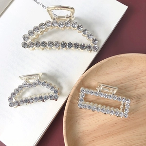 Detailed view of luxury rhinestone hair claws in geometric shapes with shimmering crystals