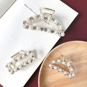 Detailed macro of golden metal hair clips with luxury pearls and sparkling rhinestones