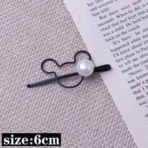 Détail d'une barrette en métal noir de 6 cm avec perle et silhouette de souris de dessin animé