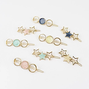 Flat lay of minimalist star and circle metal hair clips in soft Morandi colors