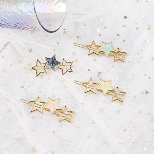 Star hair clips with gold metal frames and colorful acetate star motifs on white mesh