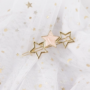 Detail of star-shaped hair clip with gold hollow stars and pink marble textured star