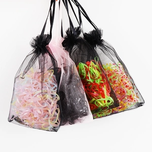 Macro detail of colorful elastic hair bands inside a translucent organza drawstring bag