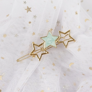 Detailed close-up of golden star hair clip with light green marble texture inlay