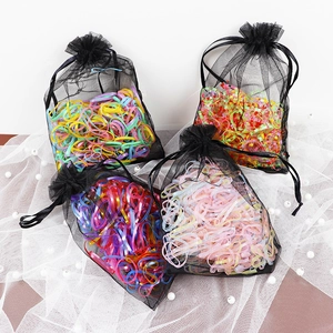 Detailed set of colorful elastic hair ties in elegant black organza drawstring gift bags