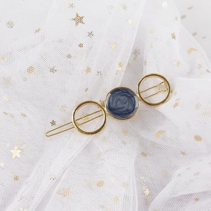 Detail of gold metal star hair clip with blue marble resin inlay on white lace mesh