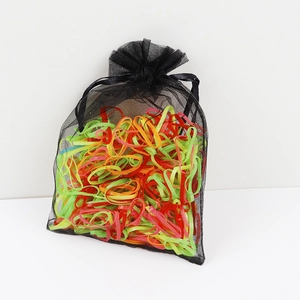 Detail showing colorful elastic hair bands packed in a black mesh organza drawstring bag