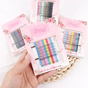 Detailed close-up of colorful wave metal bobby pins set arranged on pink card