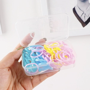 Detailed view of colorful elastic hair bands stored in a transparent plastic organizer box