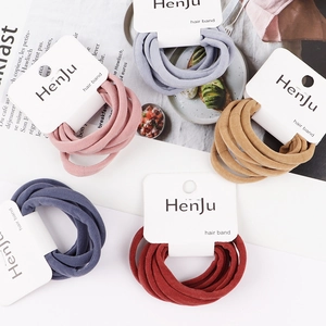 Detail of high-elasticity fabric hair ties in assorted soft colors on branded card