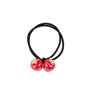 Elastico per capelli con fragola rossa carina e ciondoli a stella dorati su sfondo bianco
