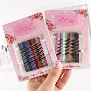 Close-up of colorful wavy metal bobby pin sets on floral card packaging with grip design