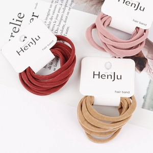 Detail of soft velvet elastic hair bands in red pink and khaki on display card