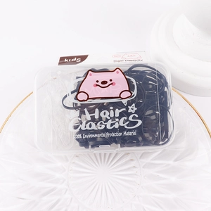 Macro shot of durable black and clear hair elastics in a cute pink cartoon storage box