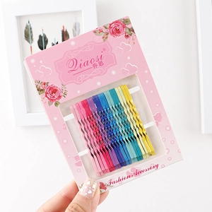 Close-up of colorful wavy bobby pins set in rainbow colors on a pink card packaging