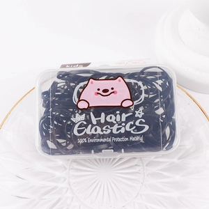 Close-up of black hair elastics for kids in a box with cute pink cat illustrations