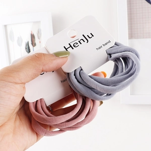 Detail of high-elasticity grey and pink hair bands on minimalist branded cards