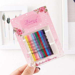 Close-up of colorful wavy metal hairpins set displayed on decorative brand card