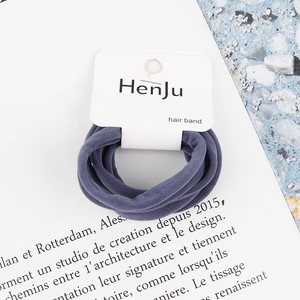 Close-up of grey-blue high-elastic hair ties on branded card with scenic background