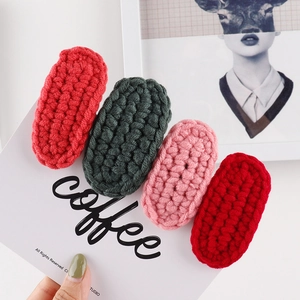 Set of four handmade crochet hair clips in red green and pink yarn with wool textures