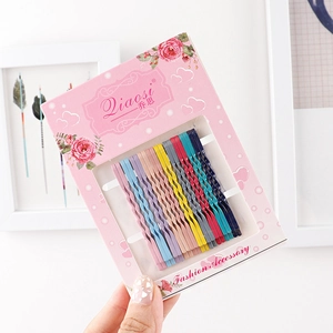 Detailed set of colorful wavy bobby pins in rainbow shades on floral packaging card