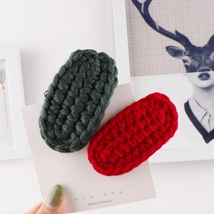Detailed macro view of handmade wool woven BB hair clips in forest green and red colors