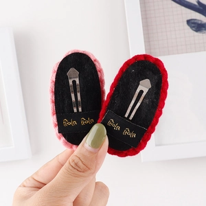 Detail of handmade crochet hair clip with embroidered brand label and metal BB grip
