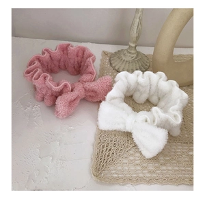 Close-up of pink and white plush bow headbands with soft flannel texture for skincare