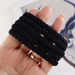 Close-up of thick black braided hair ties with durable elastic weave texture