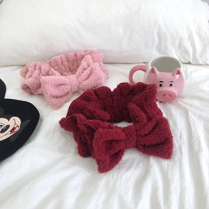 Close-up of soft coral fleece bow headbands in pink and dark red for skincare