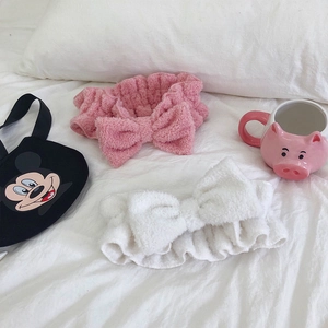 Close-up of soft pink and white microfiber bow headbands for facial skincare routines