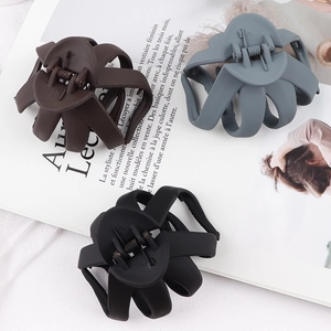 Detailed view of matte hair claws in dark brown, blue, and black on a magazine