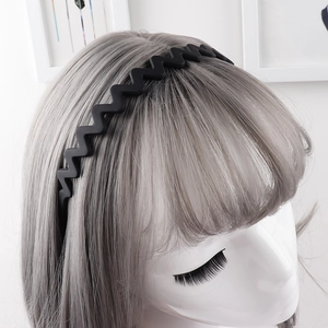 Detail of matte black wavy headband with non-slip teeth shown on a mannequin head