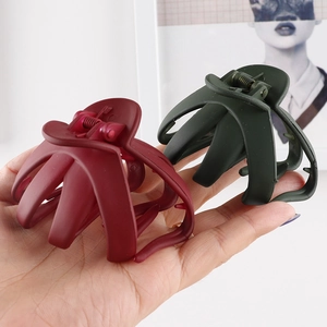 Detail view of large matte burgundy and dark green octopus hair claws for thick hair