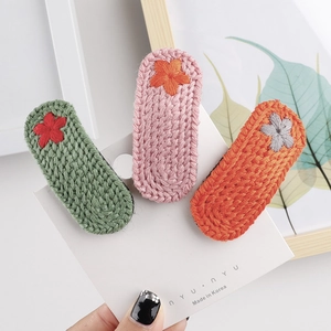 Detaillierte Ansicht eines dreiteiligen Sets handgestrickter Blumen-Haarspangen in Bunten Farben