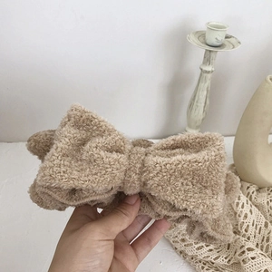 Macro detail of soft brown fleece headband with a large bow for skincare and makeup