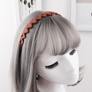 Detail of red matte wave headband with anti-slip teeth shown on model for daily hair styling