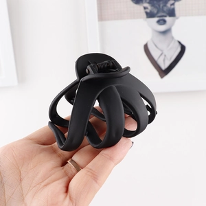 Detail of a matte black hair claw clip featuring a sturdy spring and a non-slip grip
