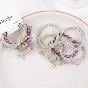 Detail of colorful braided macaron hair bands on a white ceramic display tray