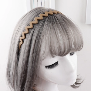 Close-up of matte brown wavy headband with anti-slip teeth shown on a model