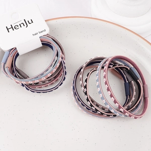 Close-up of handmade braided hair ties with floral patterns and matte resin seals