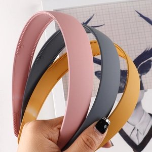 Close-up of matte headband with inner non-slip teeth in pink, grey and yellow colors