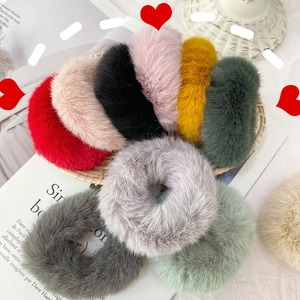 Set of colorful faux rabbit fur plush hair scrunchies displayed on a rustic tray