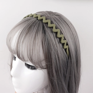 Matte olive green wavy headband with anti-slip teeth shown on a female model