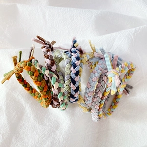 Detailed view of hand-woven braided hair ties in various vibrant color combinations