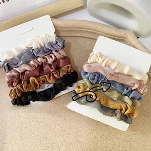 Close-up of 12-piece colorful satin scrunchies set on white U-shaped display cards