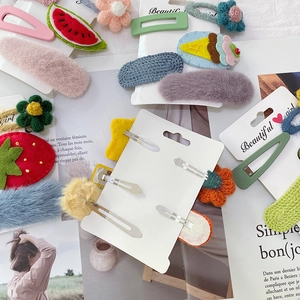 Details von bunten Plüsch- und Filz-Haarklammern mit verschiedenen Motiven auf Magazin
