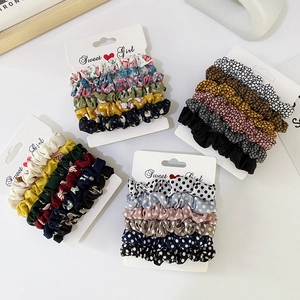 Elegant satin hair scrunchie set with floral patterns and polka dots on display cards