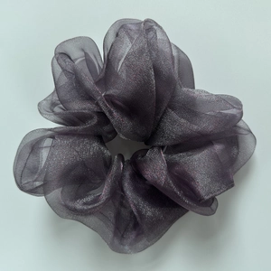 Detail von grauem Organza-Haargummi mit metallischem Schimmer und Faltenwurf