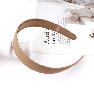 Detailed close-up of matte dark brown headband with anti-slip teeth and flexible plastic